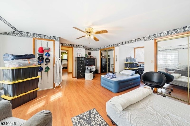 bedroom featuring a ceiling fan, two closets, and wood finished floors