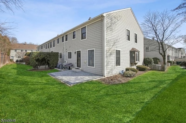 rear view of house with a patio area, fence, and a yard