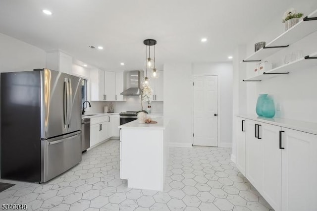 kitchen with stainless steel appliances, white cabinets, light countertops, wall chimney exhaust hood, and pendant lighting