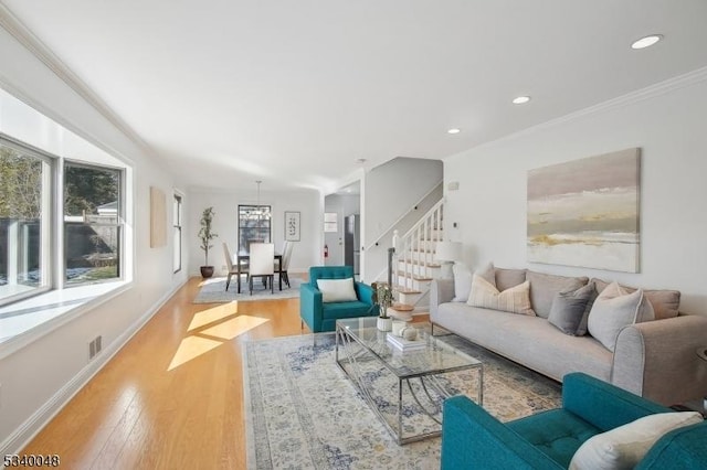 living area featuring recessed lighting, wood finished floors, baseboards, ornamental molding, and stairway