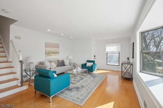 living area featuring stairs, ornamental molding, light wood-type flooring, and recessed lighting