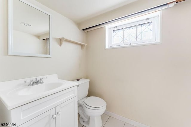 bathroom with tile patterned flooring, baseboards, vanity, and toilet