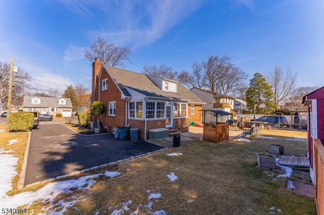 view of home's exterior with a residential view, fence, a patio, and brick siding