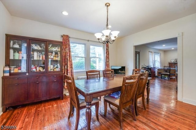 dining room with plenty of natural light, wood finished floors, and a notable chandelier