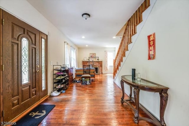 entrance foyer featuring stairs, a fireplace, wood finished floors, and recessed lighting