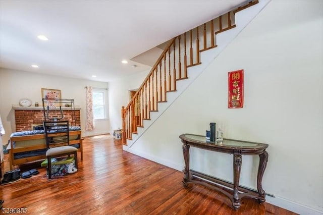 staircase featuring recessed lighting, baseboards, and wood finished floors