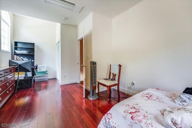 bedroom with baseboards and dark wood-type flooring