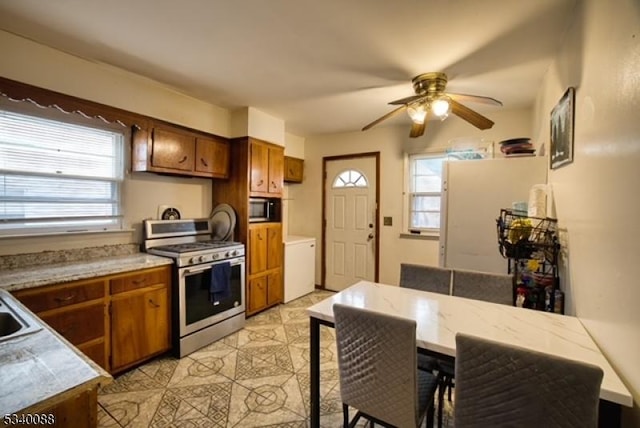 kitchen with light countertops, appliances with stainless steel finishes, and brown cabinets