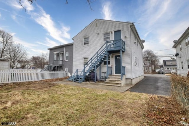 back of house with a yard and fence