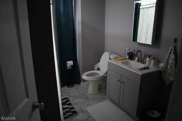 bathroom featuring toilet, marble finish floor, and vanity