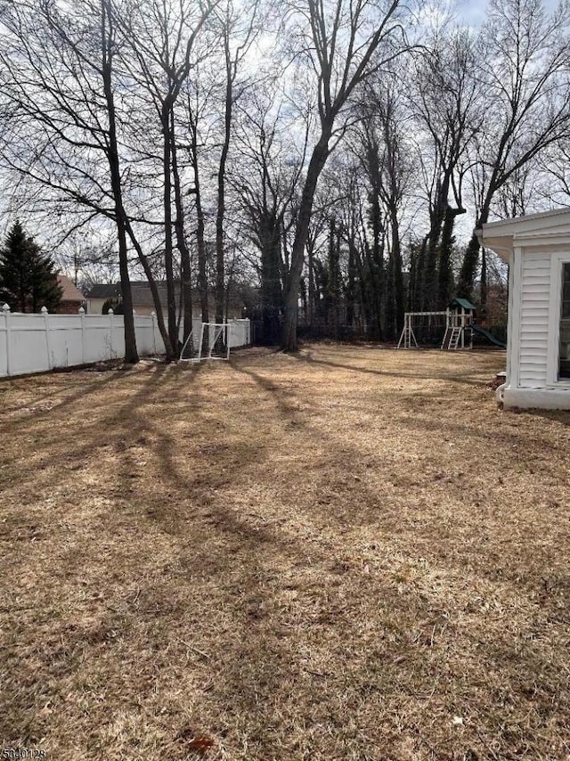 view of yard with fence and a playground