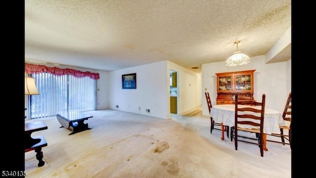 dining area featuring a textured ceiling and a chandelier