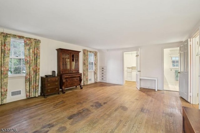 bedroom with visible vents, ensuite bath, and wood finished floors