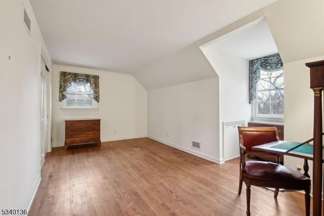 bonus room featuring light wood-type flooring, baseboards, visible vents, and lofted ceiling