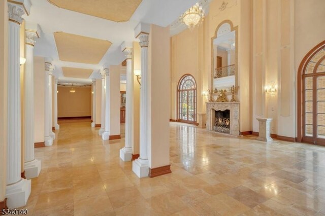 interior space with a towering ceiling, ornate columns, and baseboards