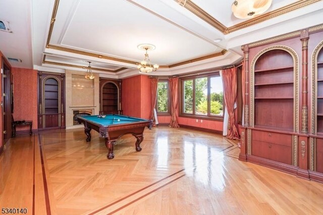 rec room featuring pool table, ornamental molding, a fireplace, and a raised ceiling