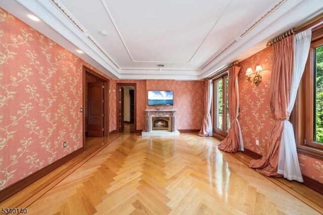 unfurnished living room with wallpapered walls, plenty of natural light, and a premium fireplace