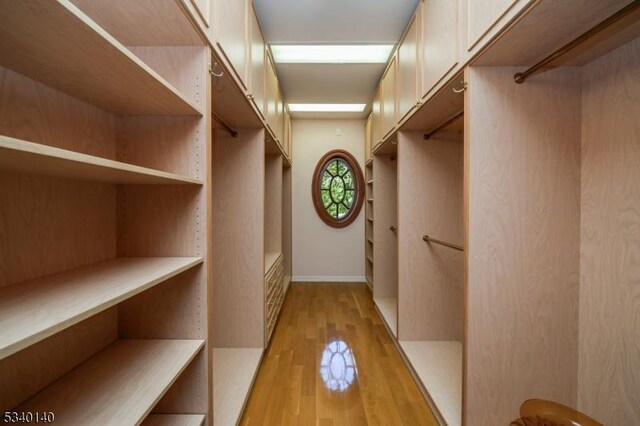 walk in closet with light wood-type flooring