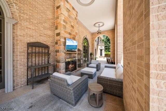 view of patio with an outdoor living space with a fireplace