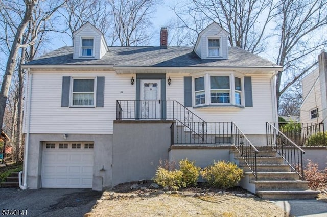 view of front of property featuring aphalt driveway, an attached garage, and a chimney