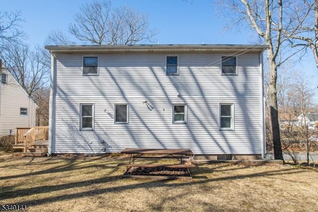 rear view of house featuring a lawn