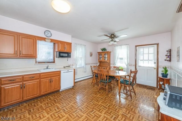 kitchen with white dishwasher, a sink, light countertops, black microwave, and a baseboard heating unit