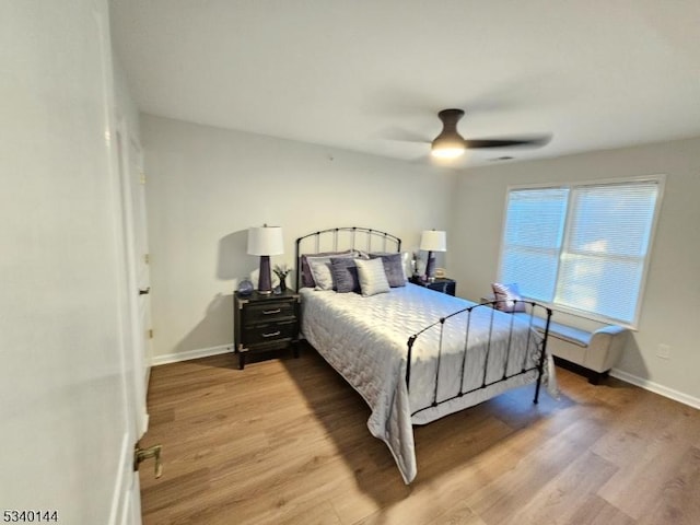 bedroom featuring baseboards, a ceiling fan, and light wood-style floors