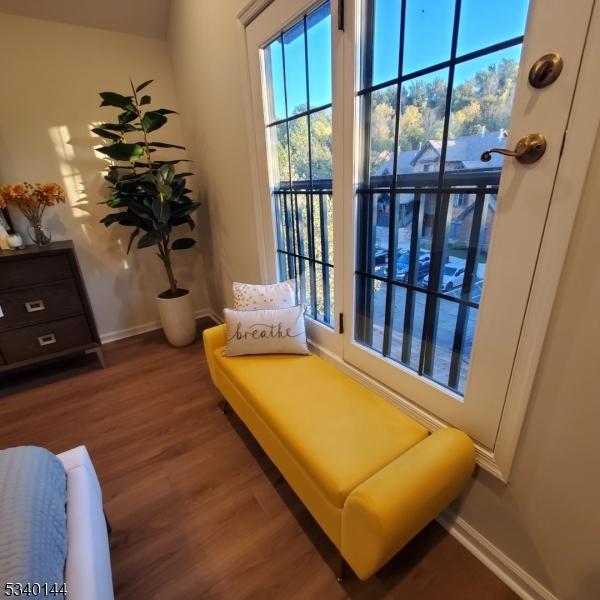 sitting room featuring baseboards and dark wood-type flooring