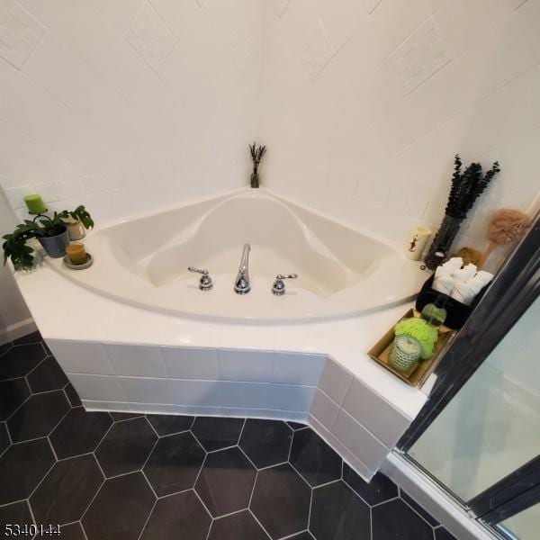 full bath featuring a shower stall, a bath, and tile patterned floors