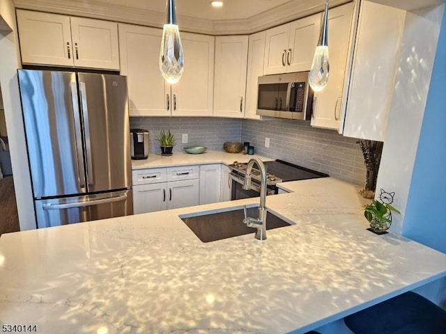 kitchen with stainless steel appliances, a sink, white cabinetry, backsplash, and light stone countertops