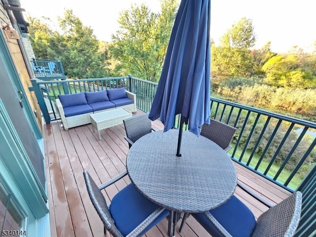 view of wooden balcony featuring a deck, an outdoor living space, and outdoor dining space