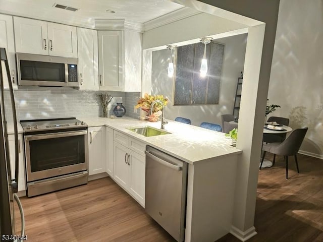 kitchen featuring a sink, visible vents, light wood-style floors, white cabinets, and appliances with stainless steel finishes