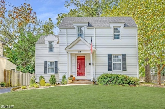 view of front of property featuring a shingled roof, a front yard, and fence