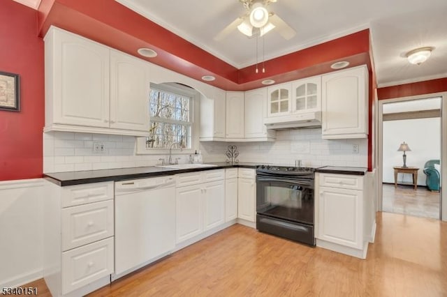 kitchen featuring black range with electric stovetop, white dishwasher, dark countertops, and a sink