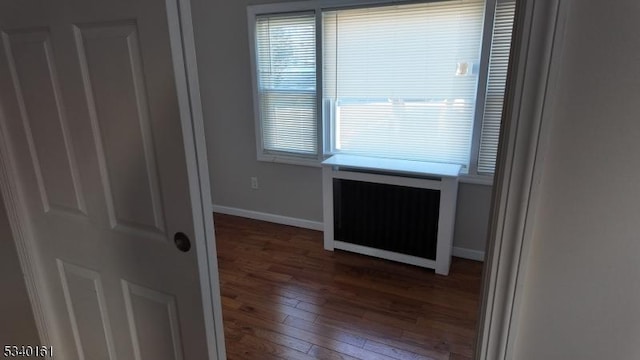 unfurnished room with radiator, hardwood / wood-style floors, and baseboards