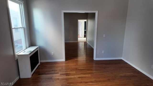 spare room with wood finished floors and baseboards