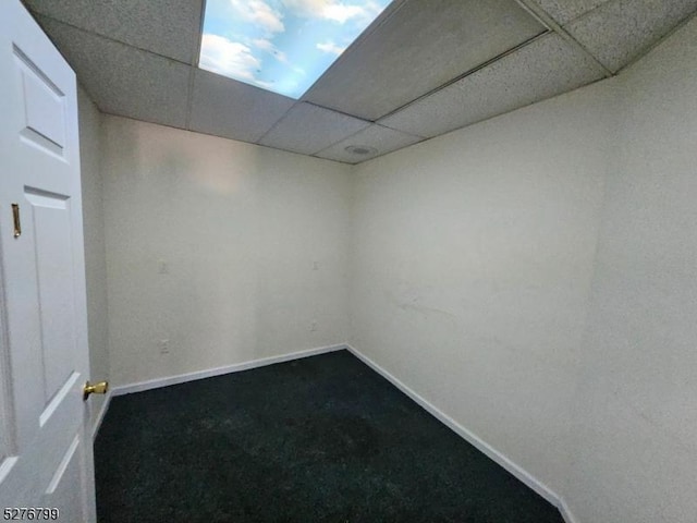 empty room with a paneled ceiling and baseboards