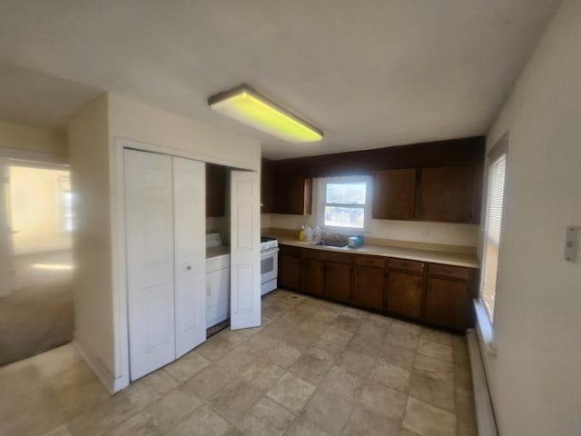 kitchen with dark brown cabinetry, white range with gas stovetop, light countertops, and baseboard heating