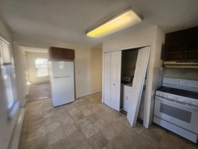 kitchen with baseboards, white appliances, dark brown cabinetry, and under cabinet range hood