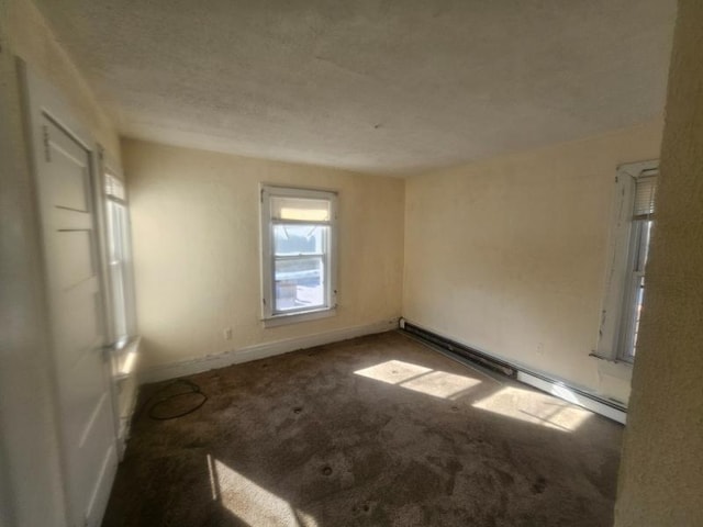 unfurnished room featuring baseboards, carpet flooring, a textured ceiling, and baseboard heating