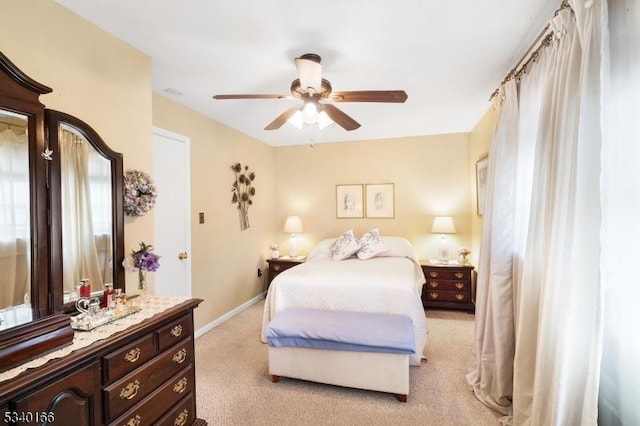 bedroom featuring ceiling fan, baseboards, and light colored carpet