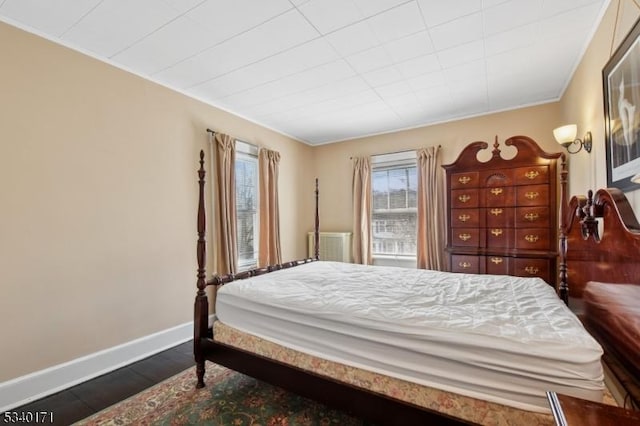 bedroom featuring dark wood-style flooring and baseboards