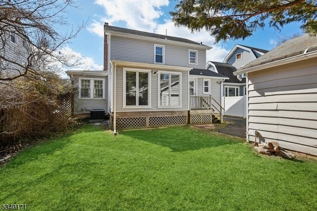 rear view of house with fence, a yard, a chimney, and central AC unit