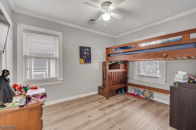 bedroom with light wood-style floors, multiple windows, visible vents, and ornamental molding