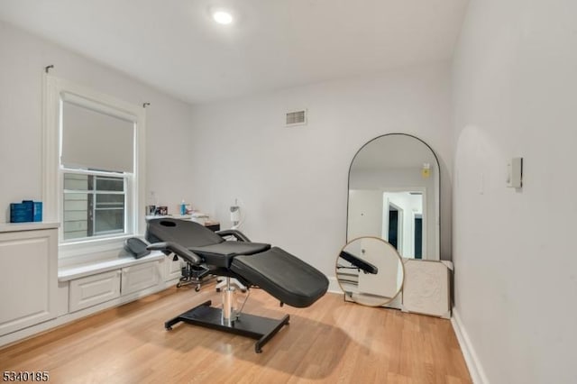 workout area featuring baseboards, visible vents, and light wood-style floors