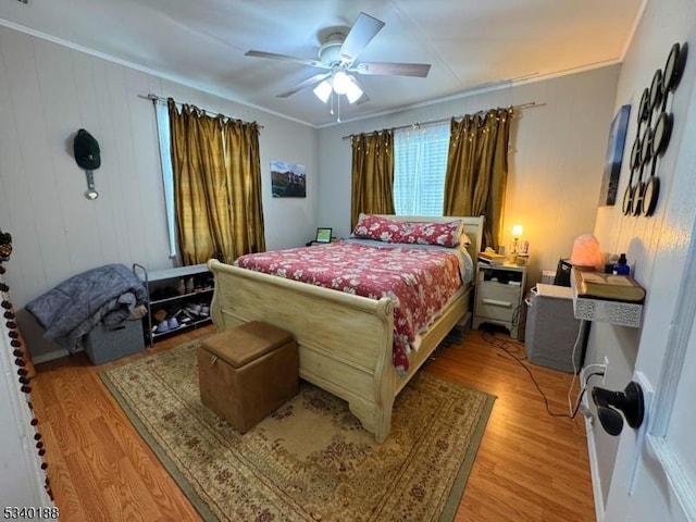 bedroom featuring ceiling fan, crown molding, and light wood-style floors