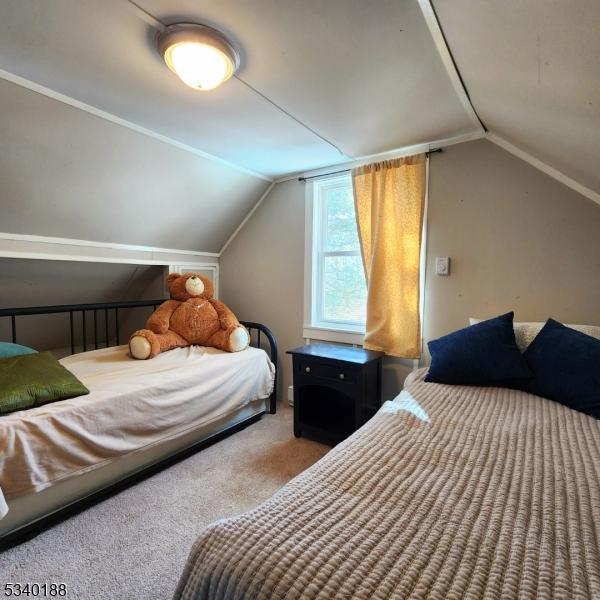 bedroom featuring vaulted ceiling and carpet flooring