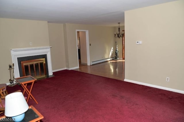 unfurnished living room featuring baseboards, a baseboard radiator, a fireplace with flush hearth, carpet, and a chandelier