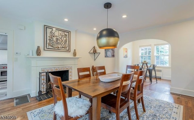 75 Crest Dr, South Orange Village Twp, NJ 07079 - dining space featuring radiator heating unit, arched walkways, ornamental molding, a fireplace, and wood finished floors