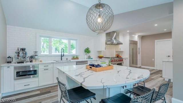 75 Crest Dr, South Orange Village Twp, NJ 07079 - kitchen featuring high end appliances, wall chimney range hood, a sink, backsplash, and white cabinets